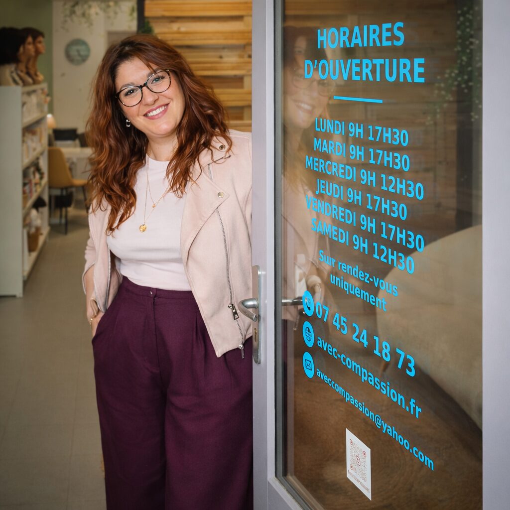Conseillère souriante accueillant les clients chez prothese-perruque-albi dans un salon chaleureux et moderne à Albi